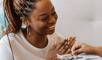black woman with braids smiling and clapping
